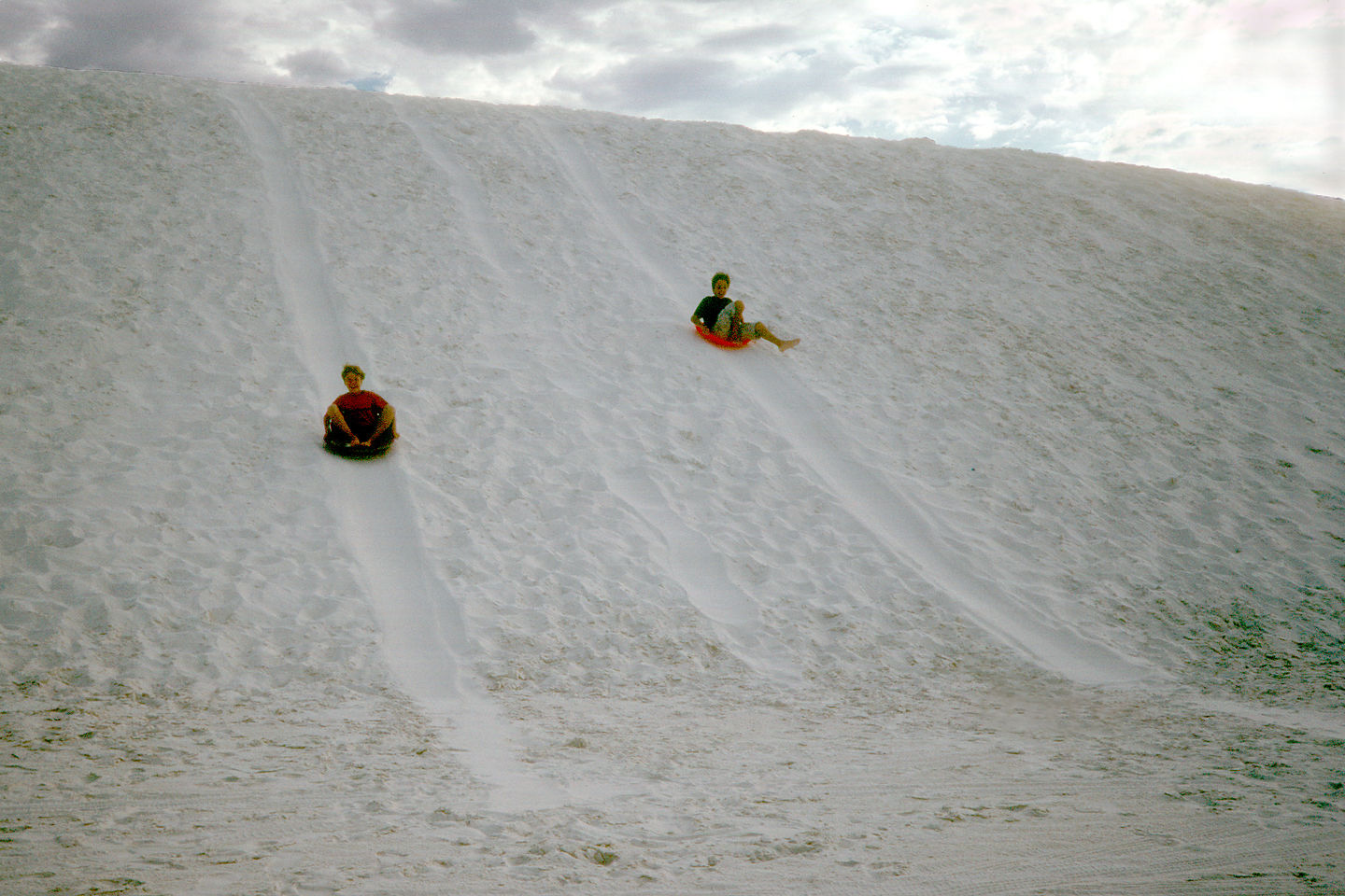 Boys saucering down dunes