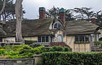 Fairy-tale gingerbread houses with stone chimneys and wavy pitched roofs.